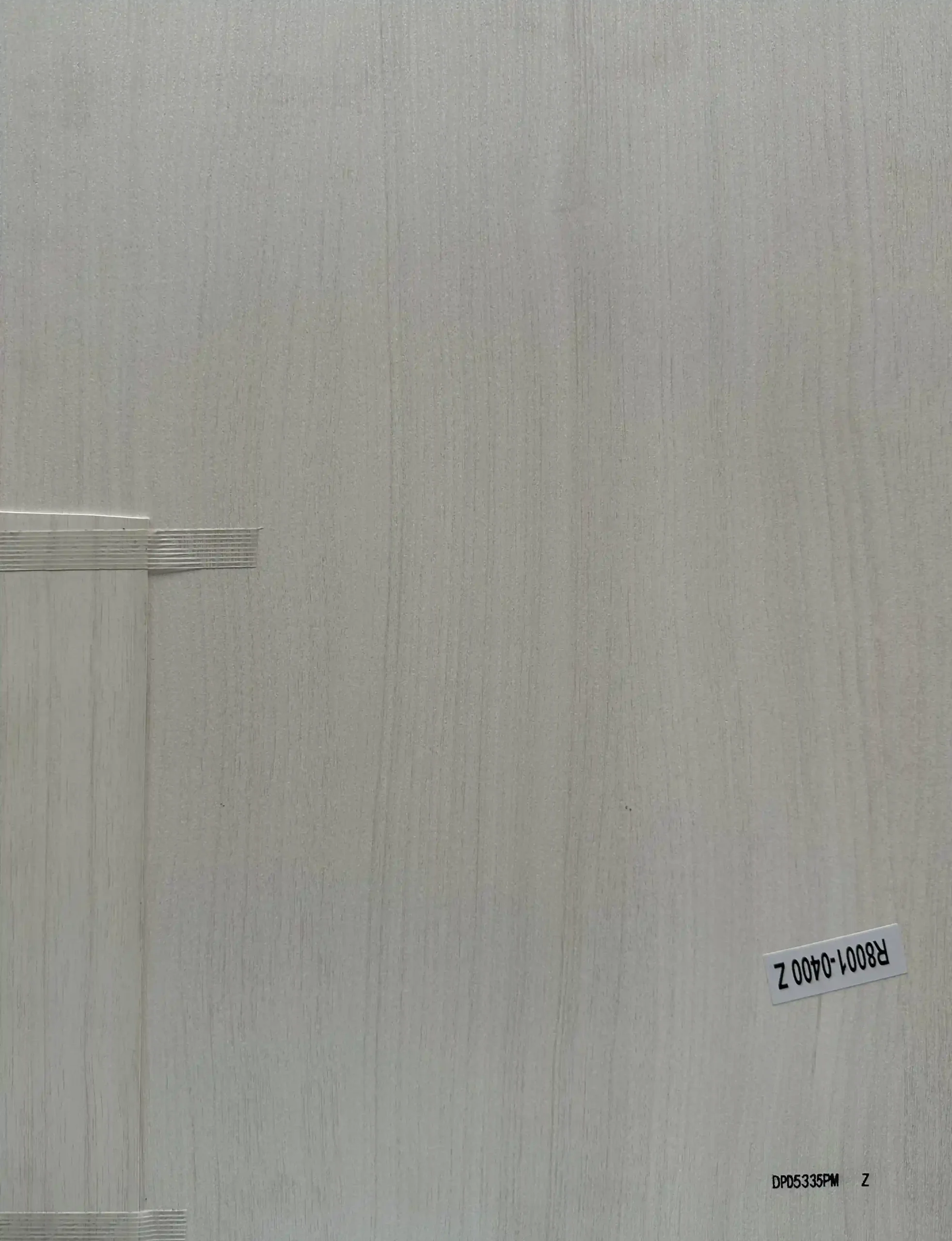 Light grey wood grain board sample with matching edge banding strip for cabinet doors and interior furniture panels DPD5335PM Z