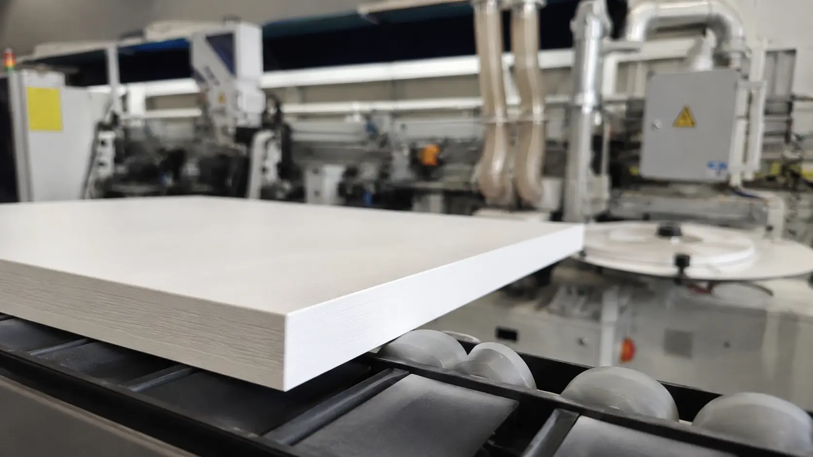 Finished white panel with PVC edge banding after machine processing